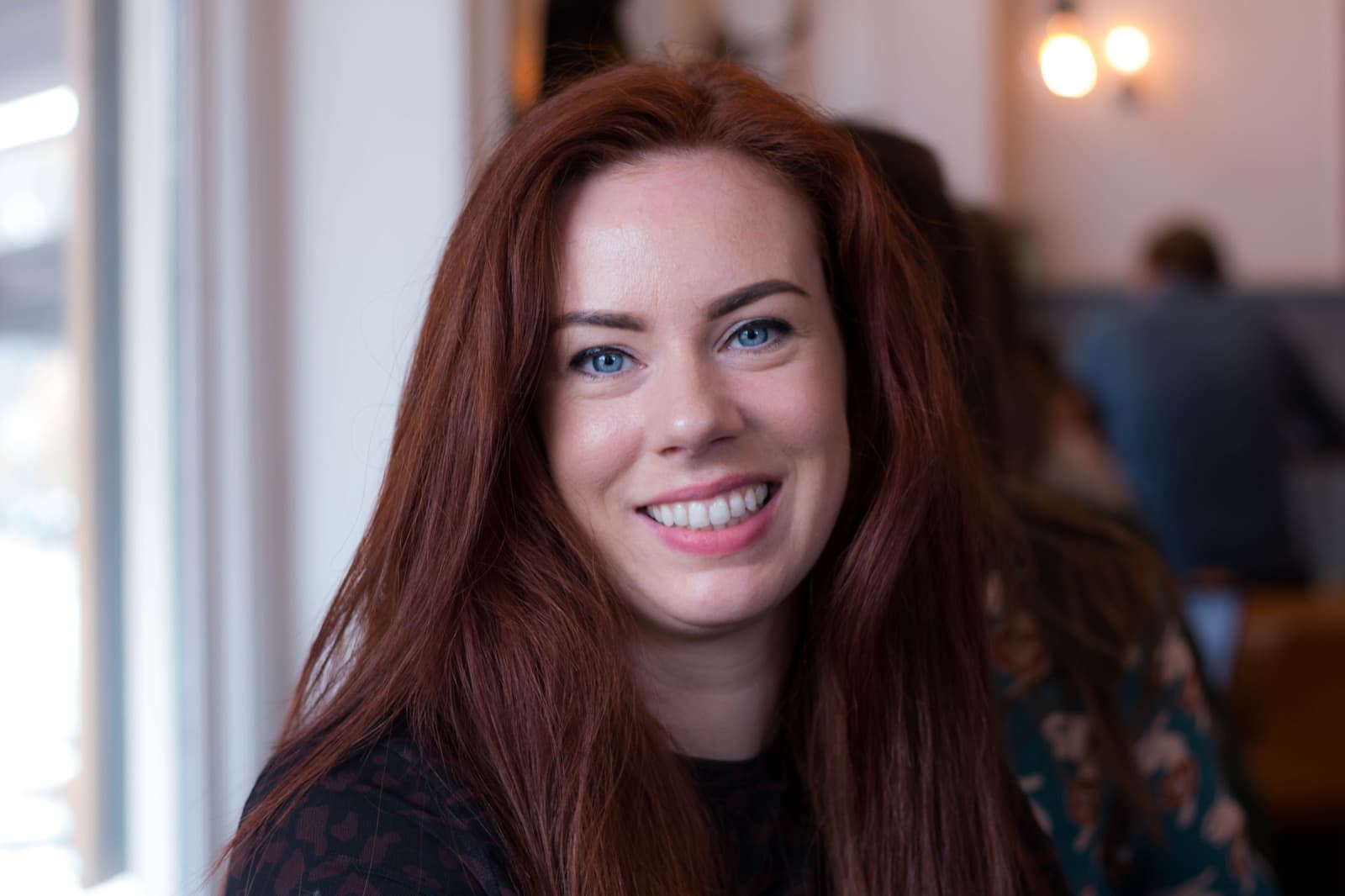 Frankie, smiling to camera in a café
